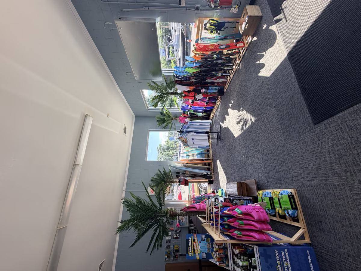 Dentro de la tienda de Wake Club en Lake Hopatcong — wakeboards, esquís acuáticos, chalecos y equipo en los racks